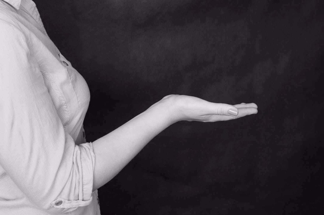 Lehrperson lädt mit Handgeste zum Mitmachen ein